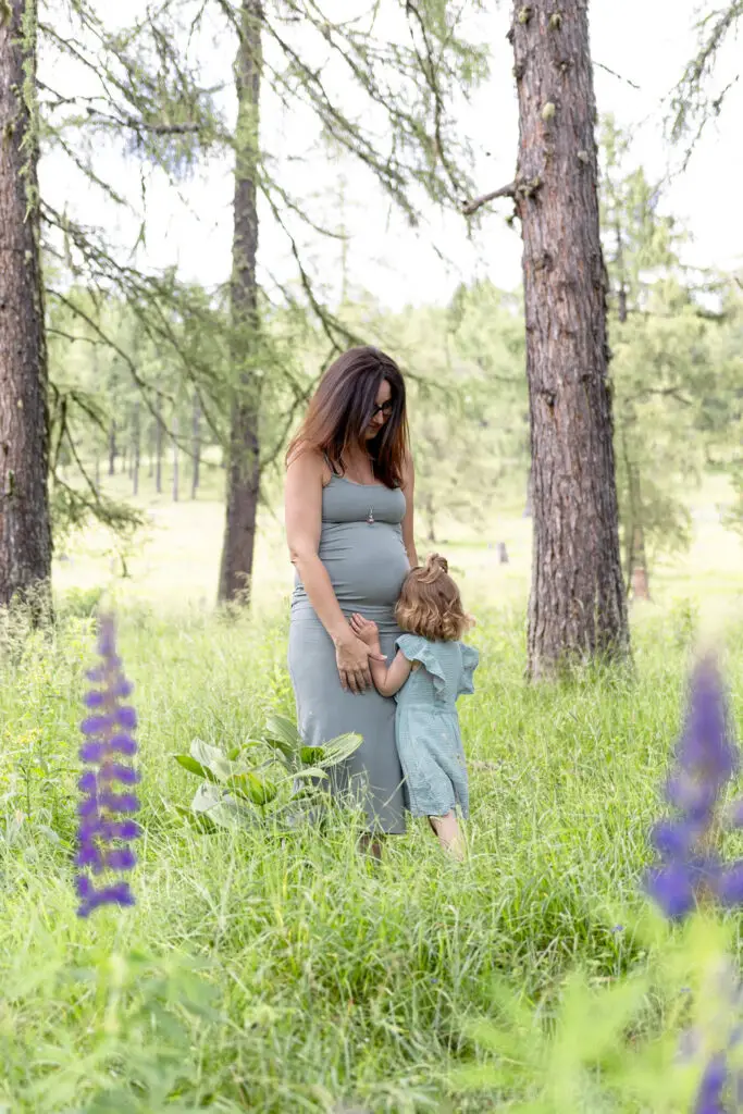 Babybauchshooting-im-hohen-Gras-am-Waldrand