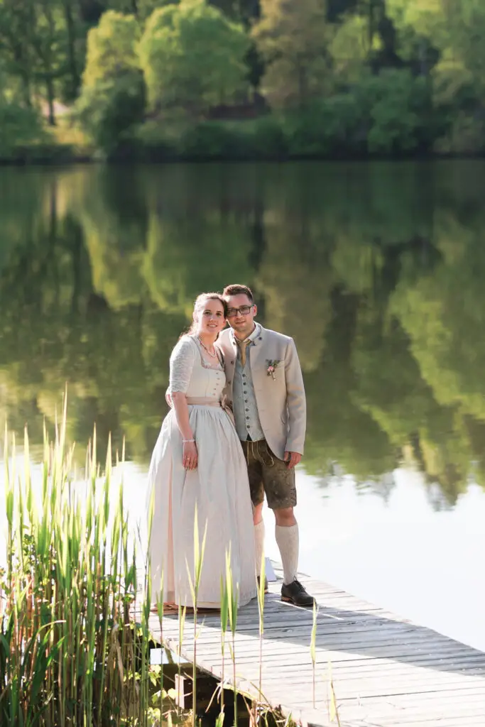 Hochzeitsbilder-am-Steg-mit-der-Spiegelung-des-Waldes-im-Wasser