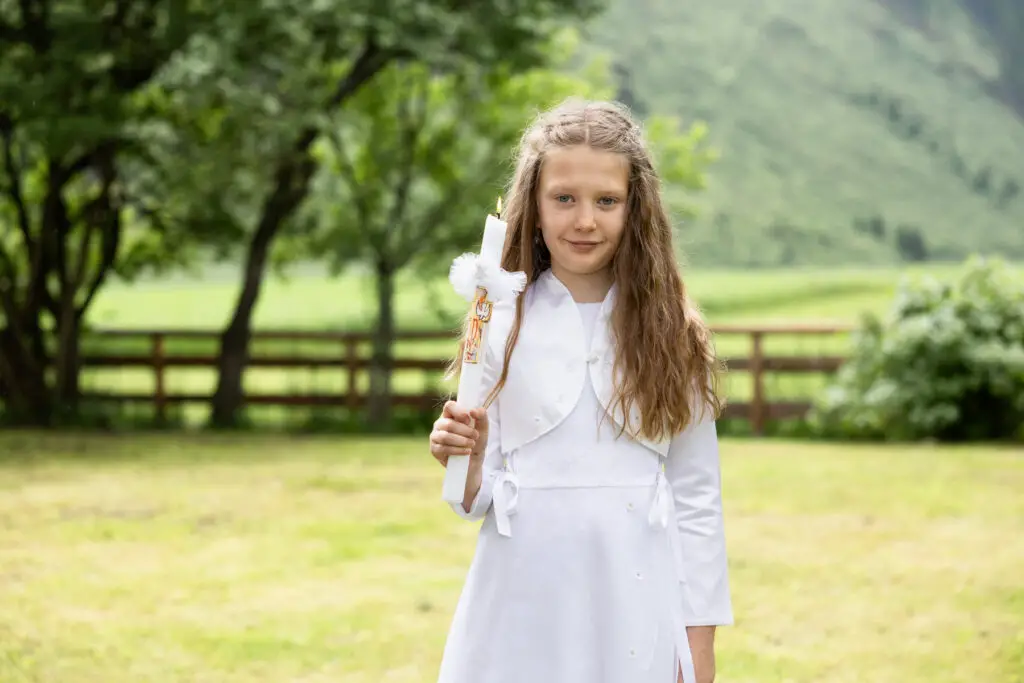 Erstkommunionskind-mit-Kerze-in-der-Hand-als-Einzelportrait
