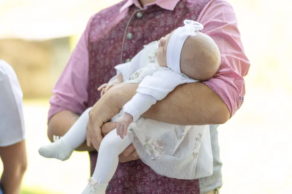 Papa-hat-Taufkind-auf-dem-Arm-beim-Empfang-vor-der-Kirche